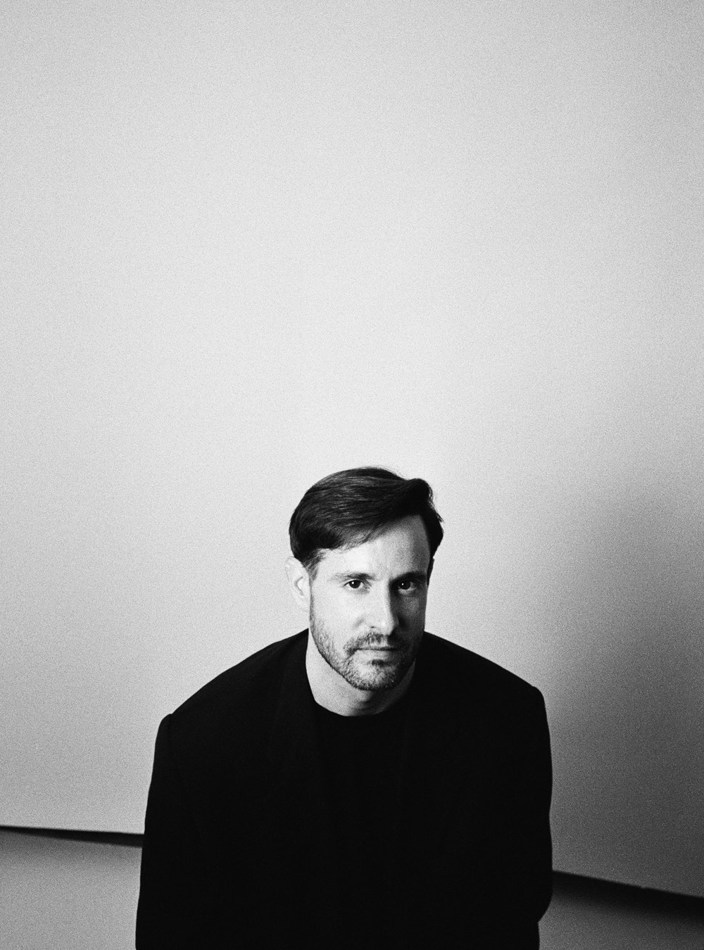 Lusean — electronic music artist, seated portrait